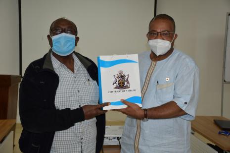 Prof. Adogame receiving a gift from the team handed by Prof. Akaranga